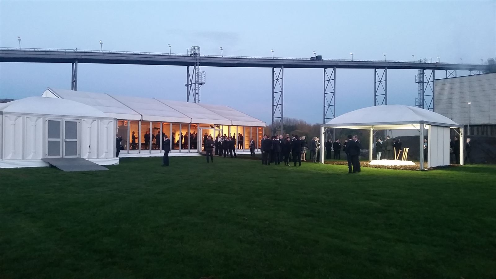 Beleuchtete Eventzelte auf einem Industriegelände in der Abenddämmerung