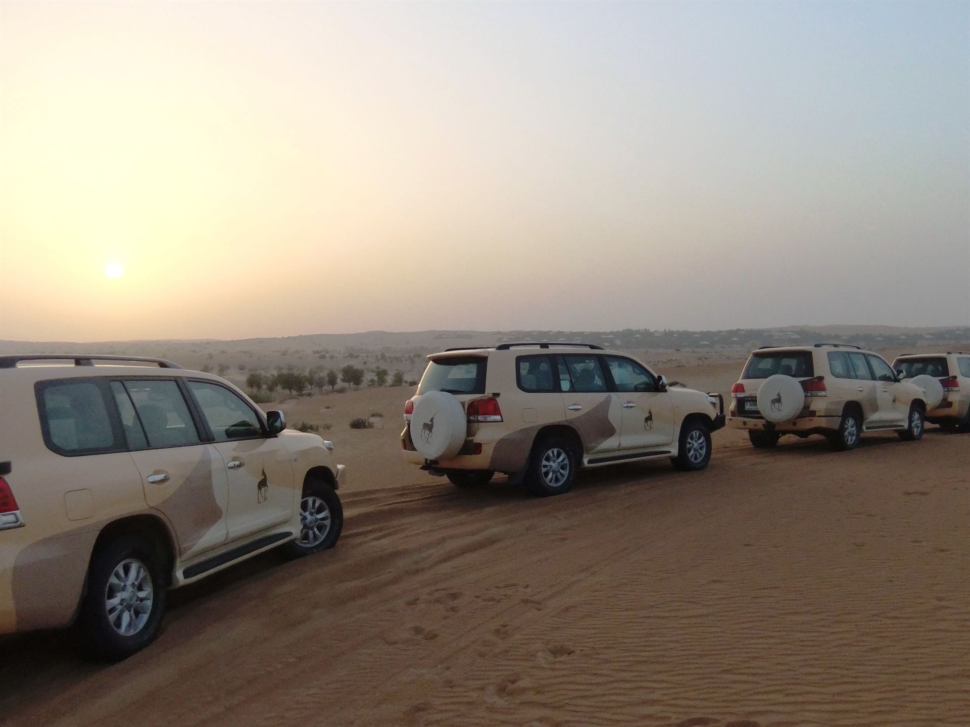 Geländewagen-Konvoi bei Sonnenuntergang in der Wüste von Dubai